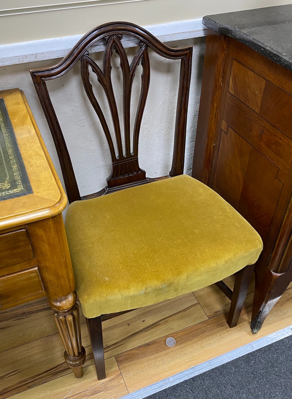 A pair of George III Hepplewhite style mahogany dining chairs, with stuff-over seats, on square tapering legs